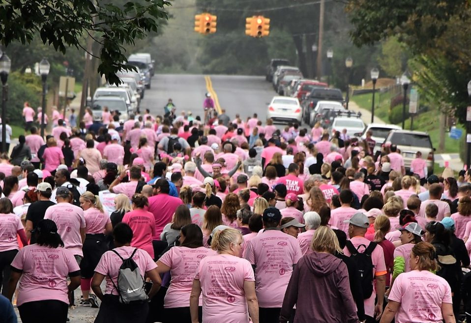 Crowd walking down street with Pink shirts